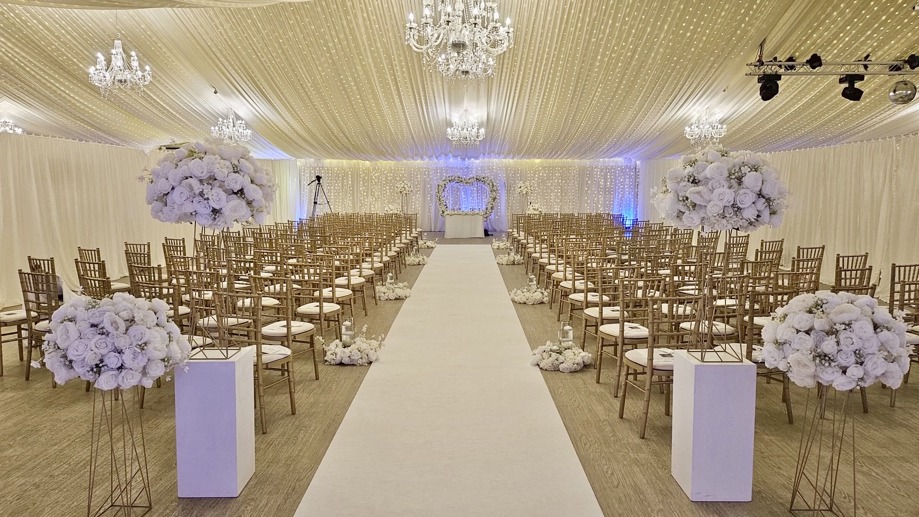 Ceremony room decorated with fairy lights, chandeliers and flowers 